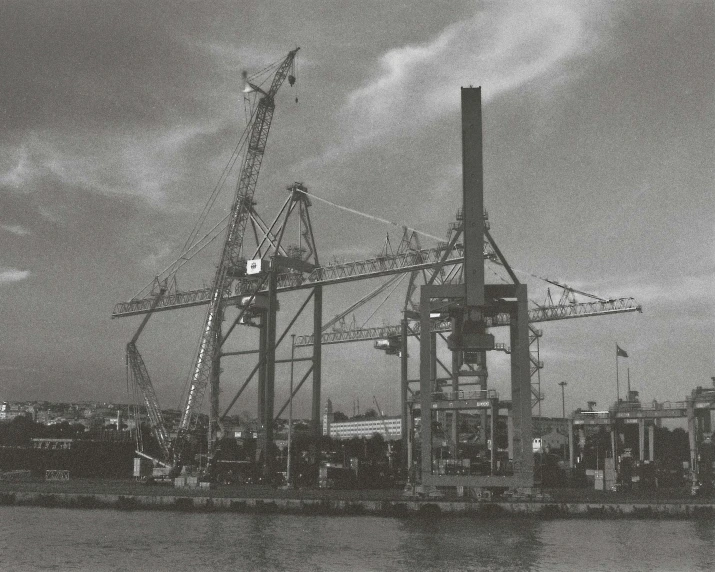 an old black and white po of cranes in harbor