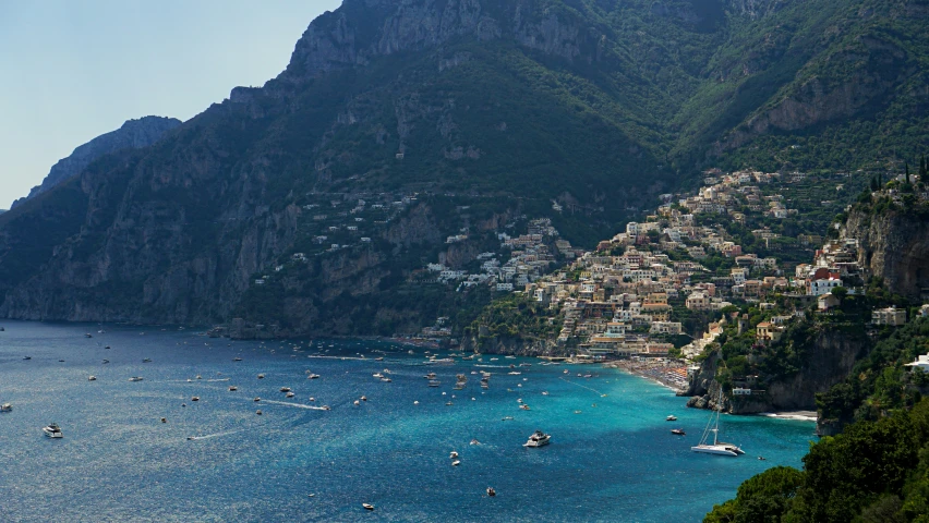 some boats that are in the water near some mountains