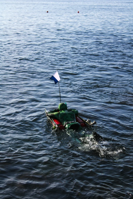 the person is in a green raft paddling on a large body of water