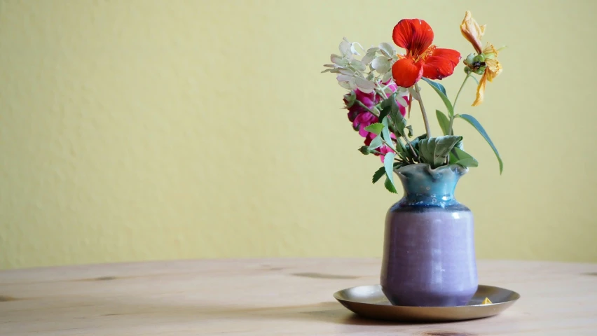 three small vases of flowers are shown sitting on the table