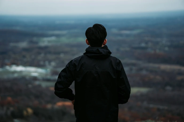 a person standing up looking out over a large open valley