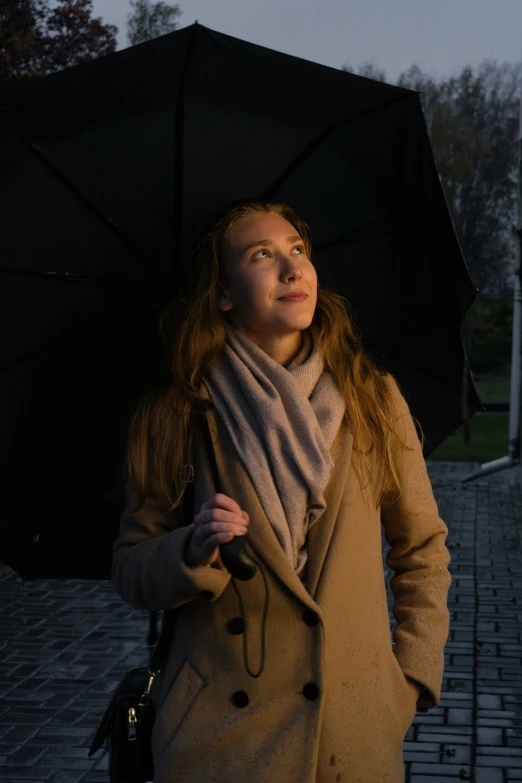 a woman standing next to stairs in the rain