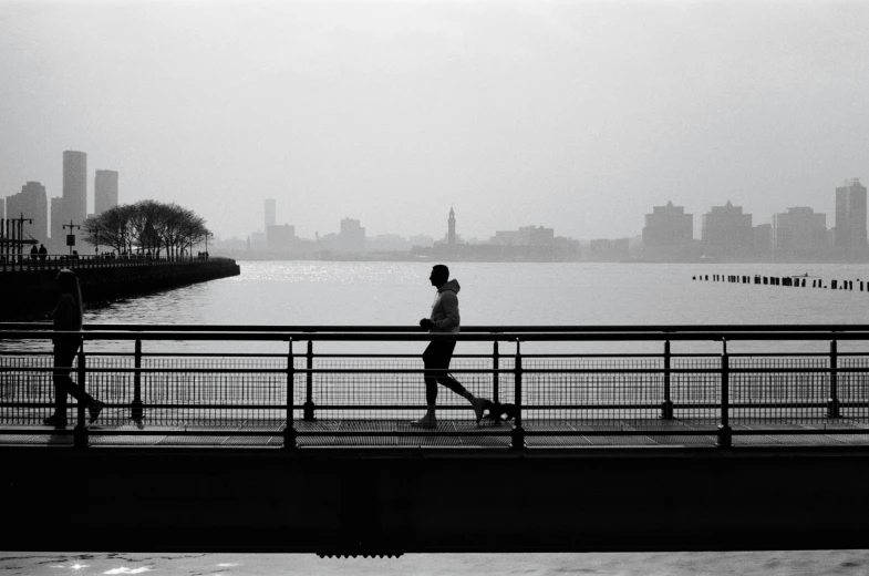 two people are walking along the pier near the water