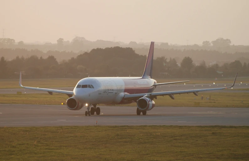 an airplane is sitting on a runway near the grass