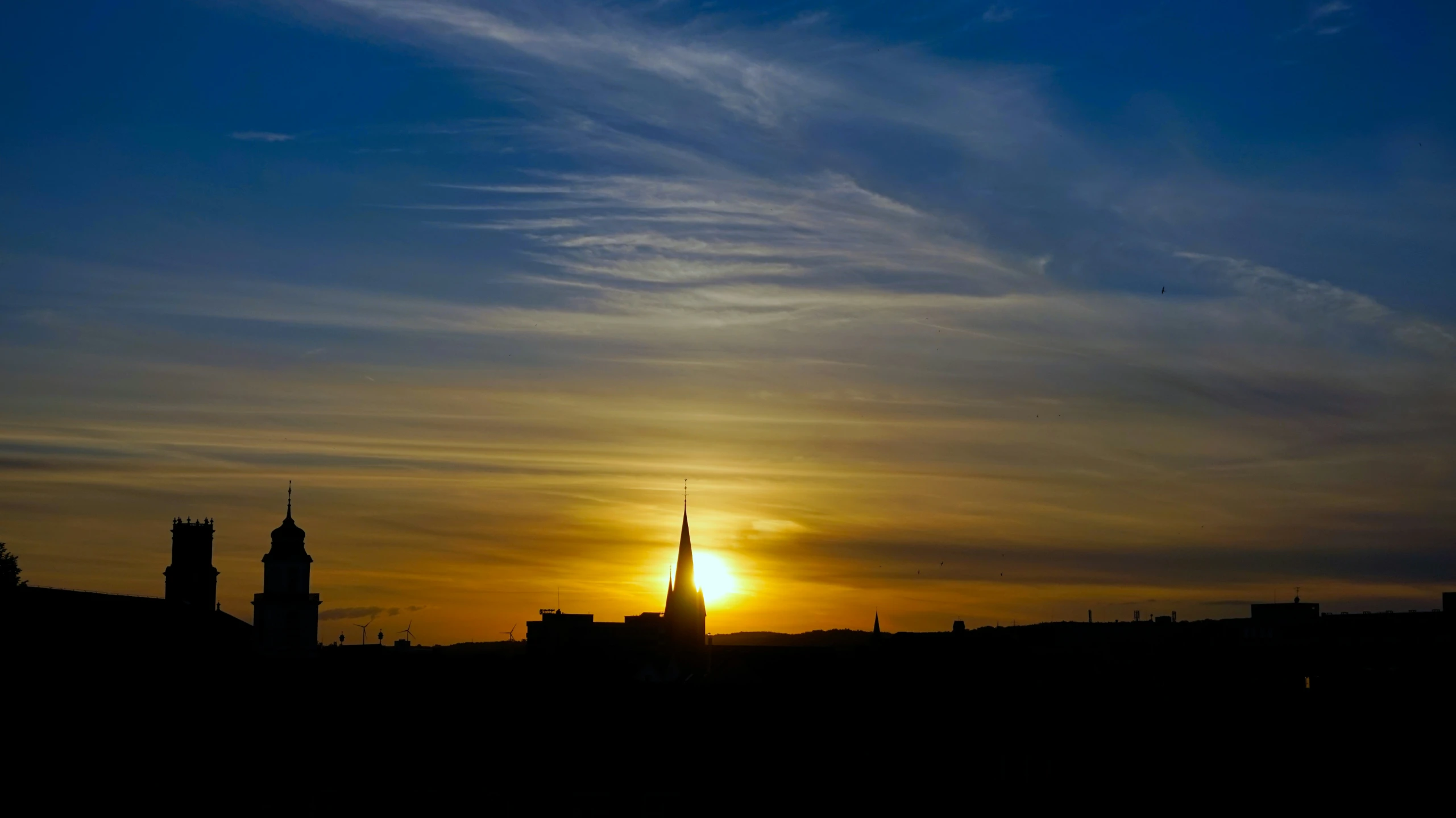 a tower and city skyline silhouetted at sunset