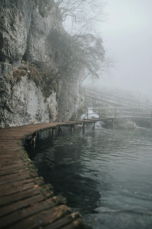 a pier on a misty day on a lake