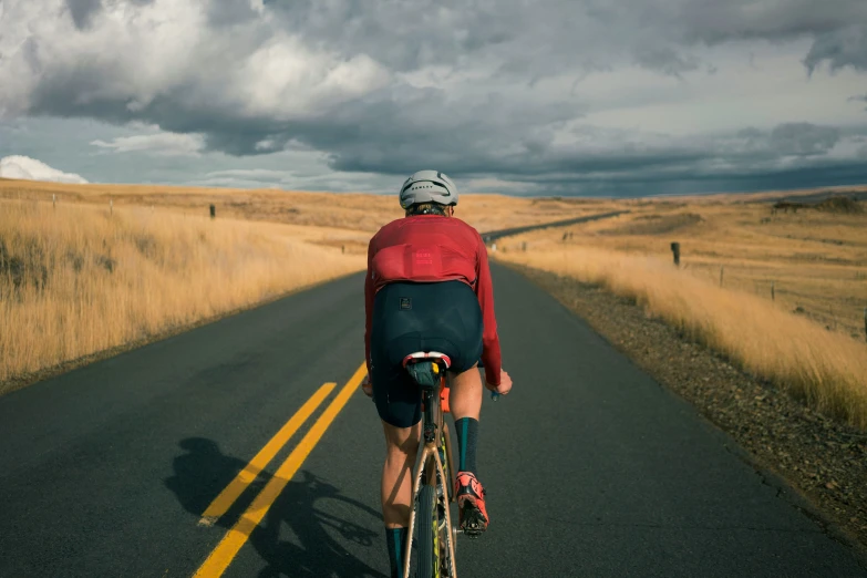 a person riding a bicycle down a country road