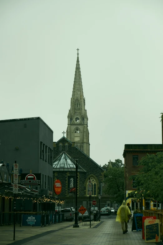 a tall church spire with a clock on it is seen through a pedestrian crossing