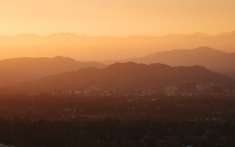 the sun shining on the mountains from a distance