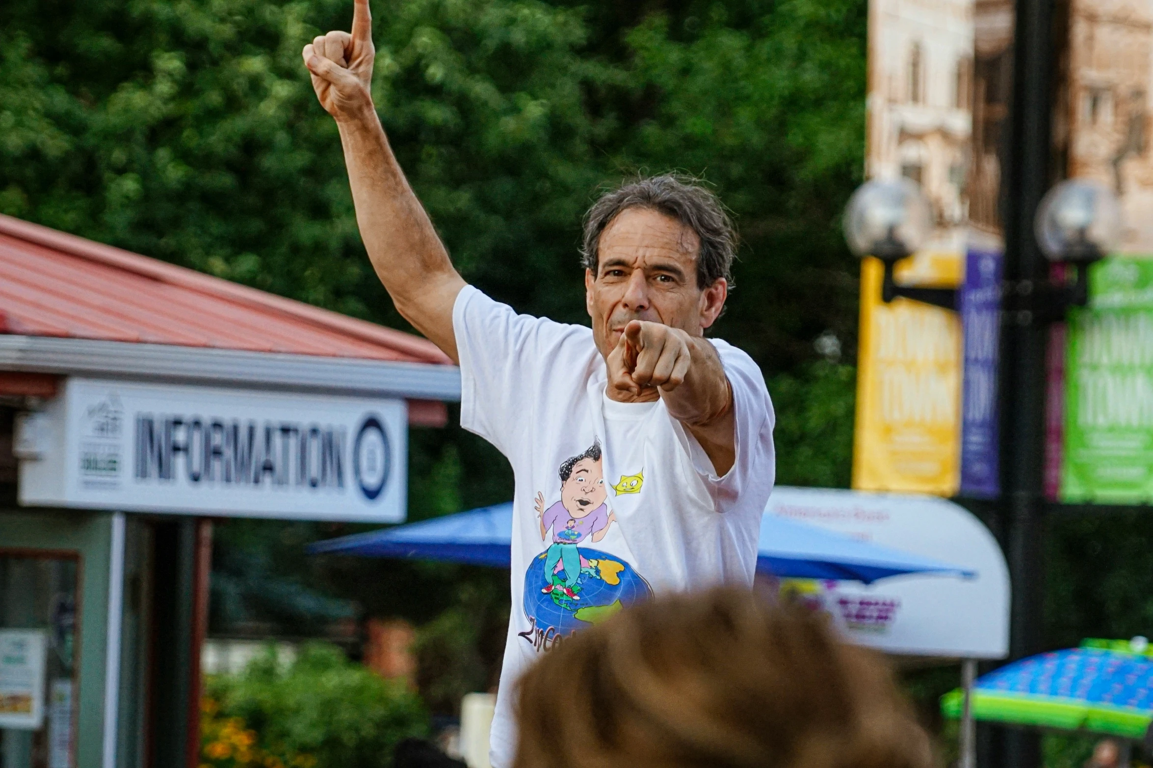 an older man in a street pointing out at people