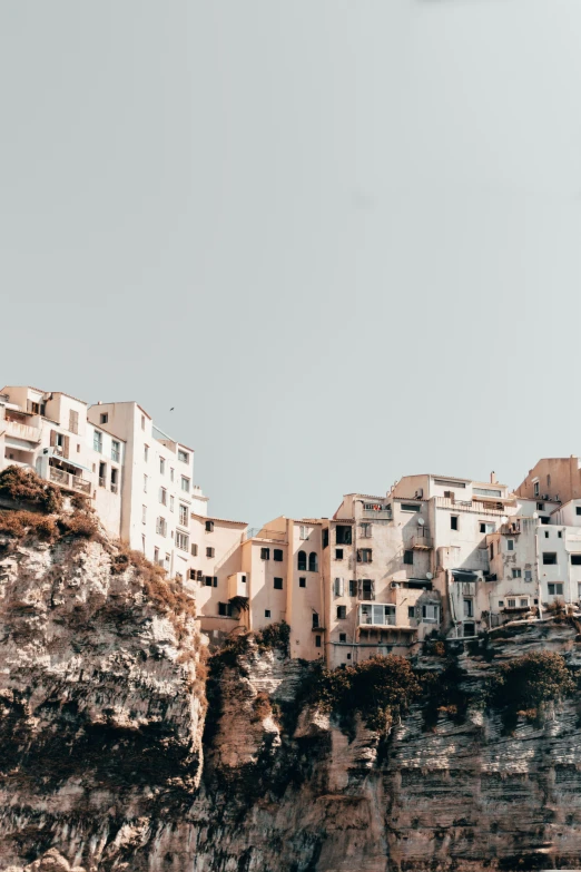 buildings are on the side of a hill next to the ocean