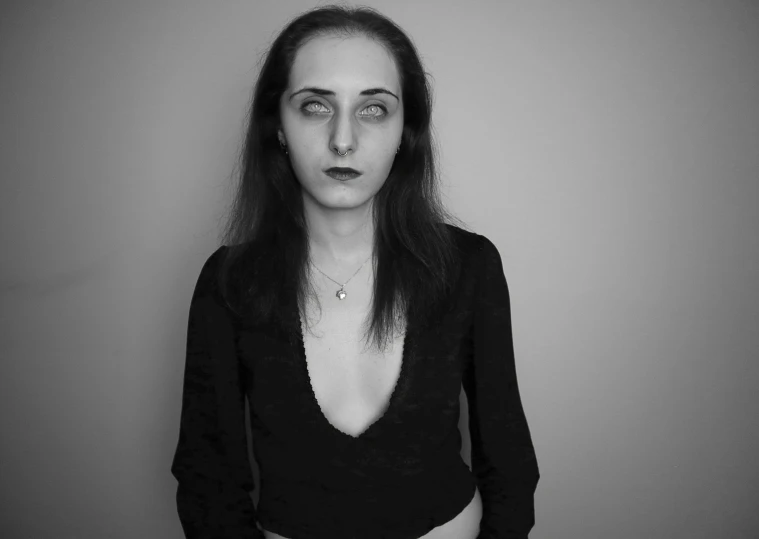 a woman with a black top on posing in a dark room
