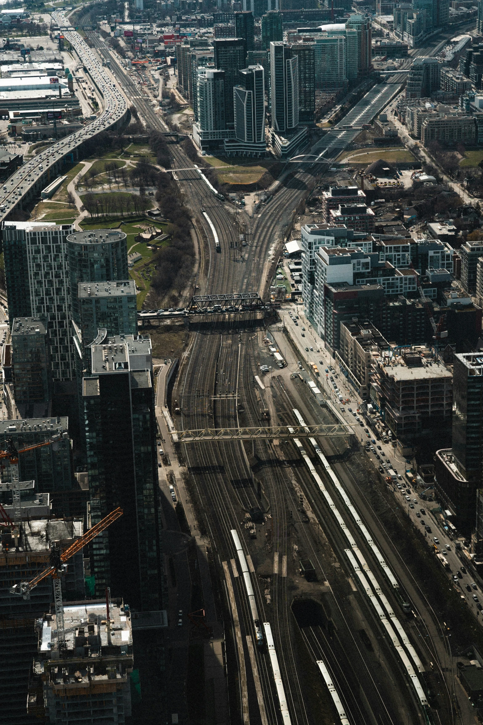 city area with roads and railroad tracks in the foreground