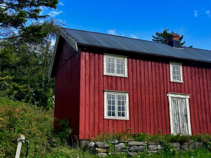 a tall red building is sitting in the grass