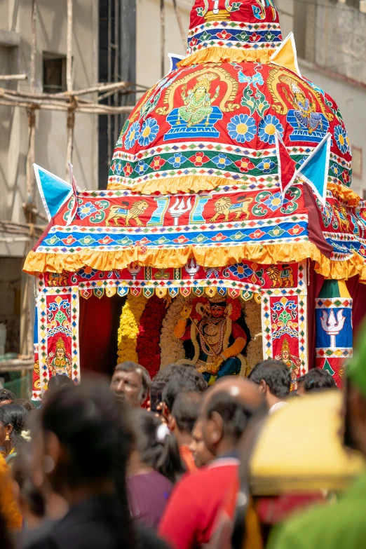 a big colorful umbrella with people surrounding it