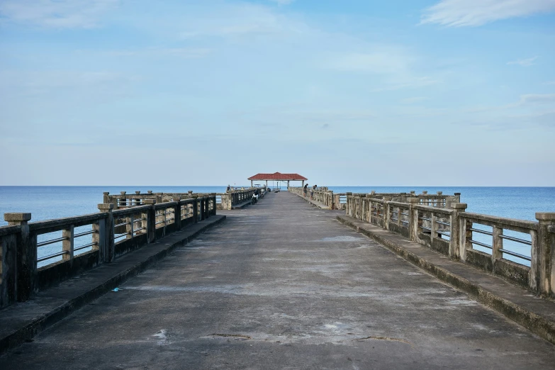 a pier that leads to the ocean next to a beach