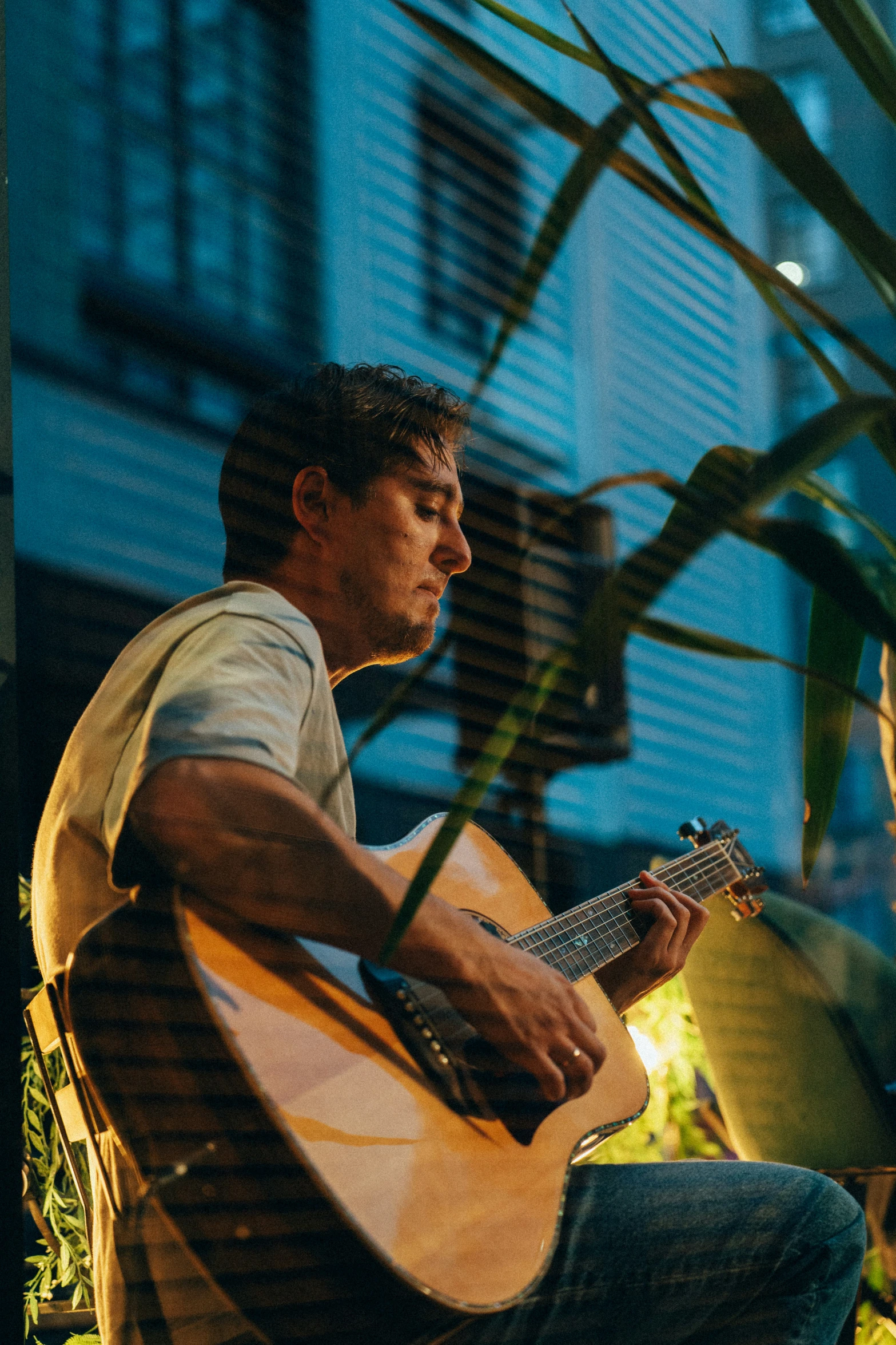 a man holding a guitar sitting on top of a chair