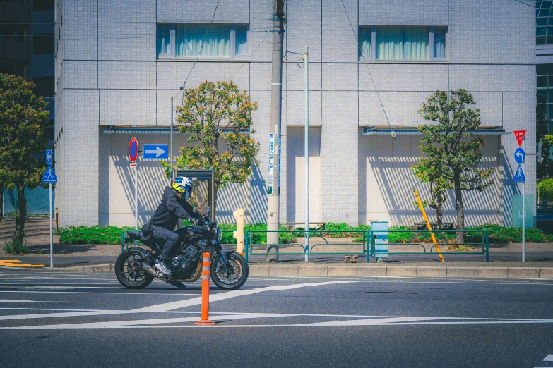 a motorcyclist passing through the street next to a building