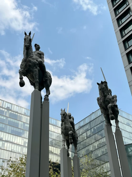 sculptures of three dogs on legs in a city square