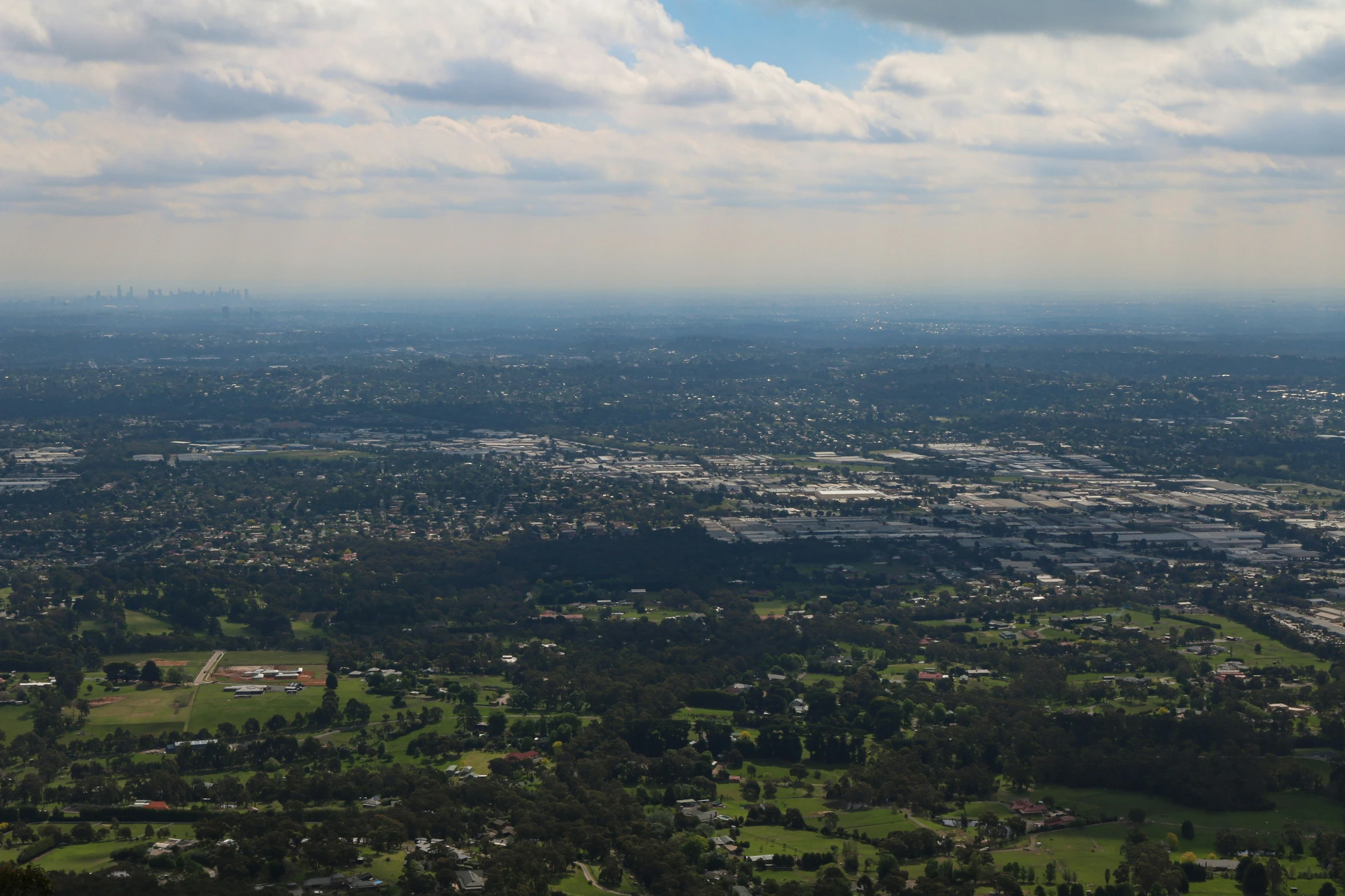 aerial view of city and hills with cloudy sky