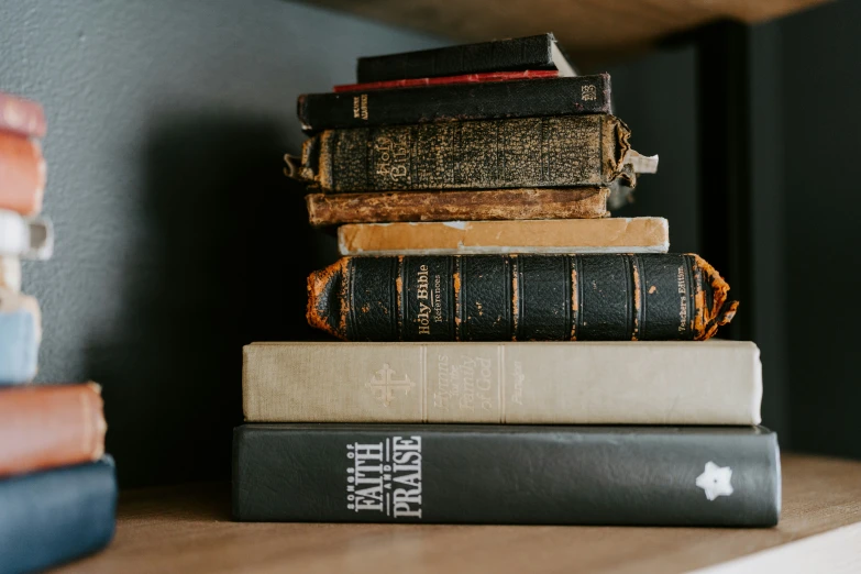 a stack of books on a shelf with other books