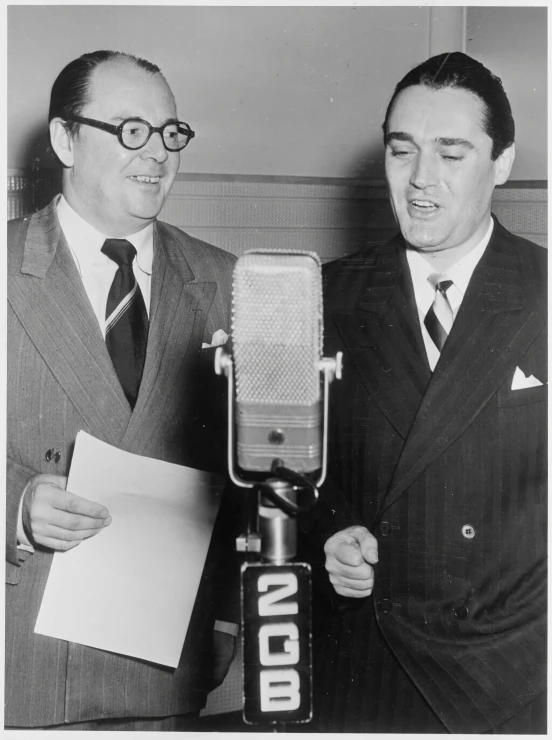 two men wearing suit and tie standing next to each other and talking