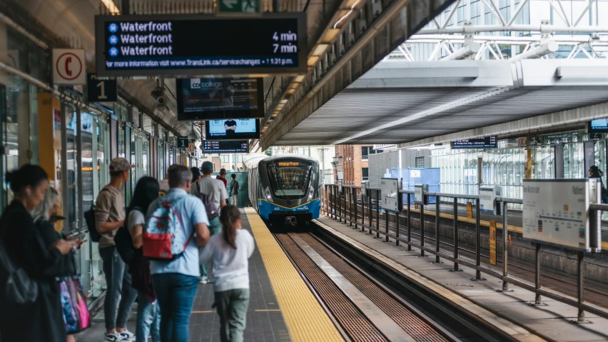 people walking beside the trains at a train station