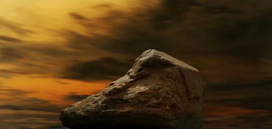 a piece of stone on top of a beach under a cloudy sky