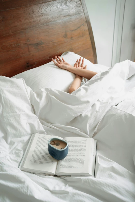 a person is laying in bed with books
