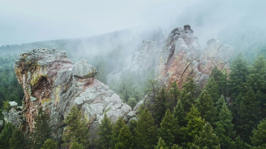 the view of two rocky mountains in a misty sky