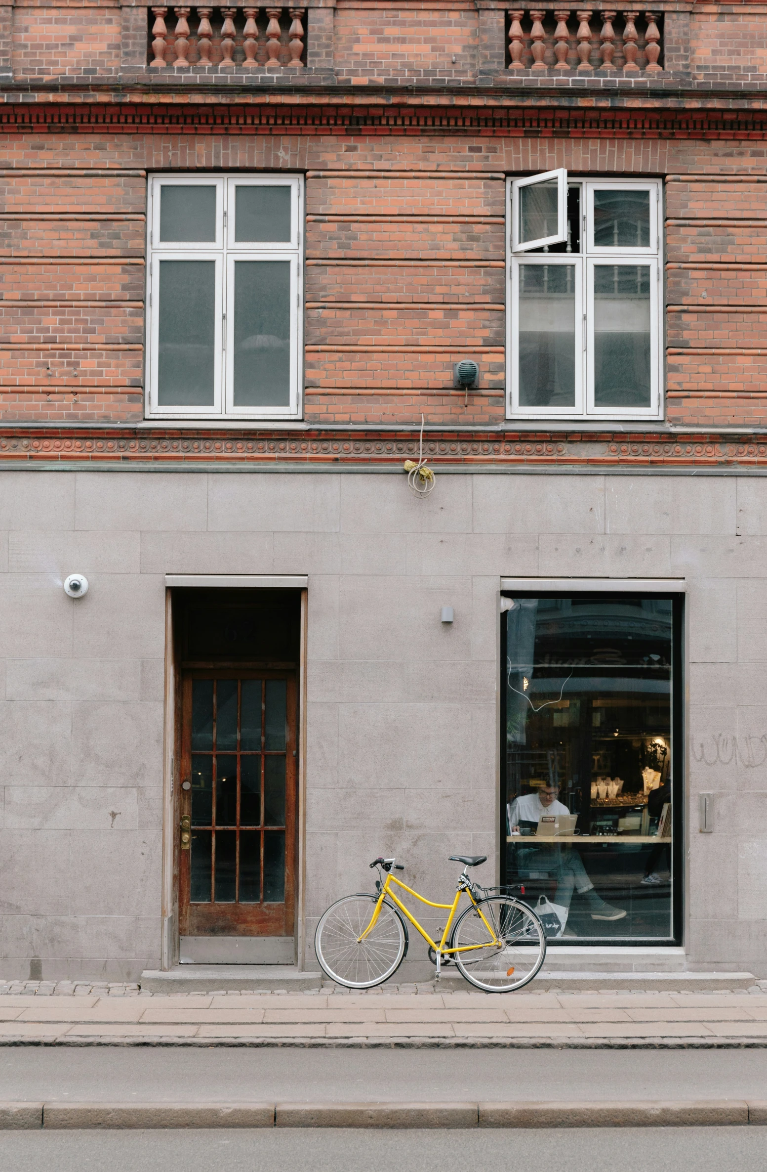 a yellow bicycle parked on the side of a grey building