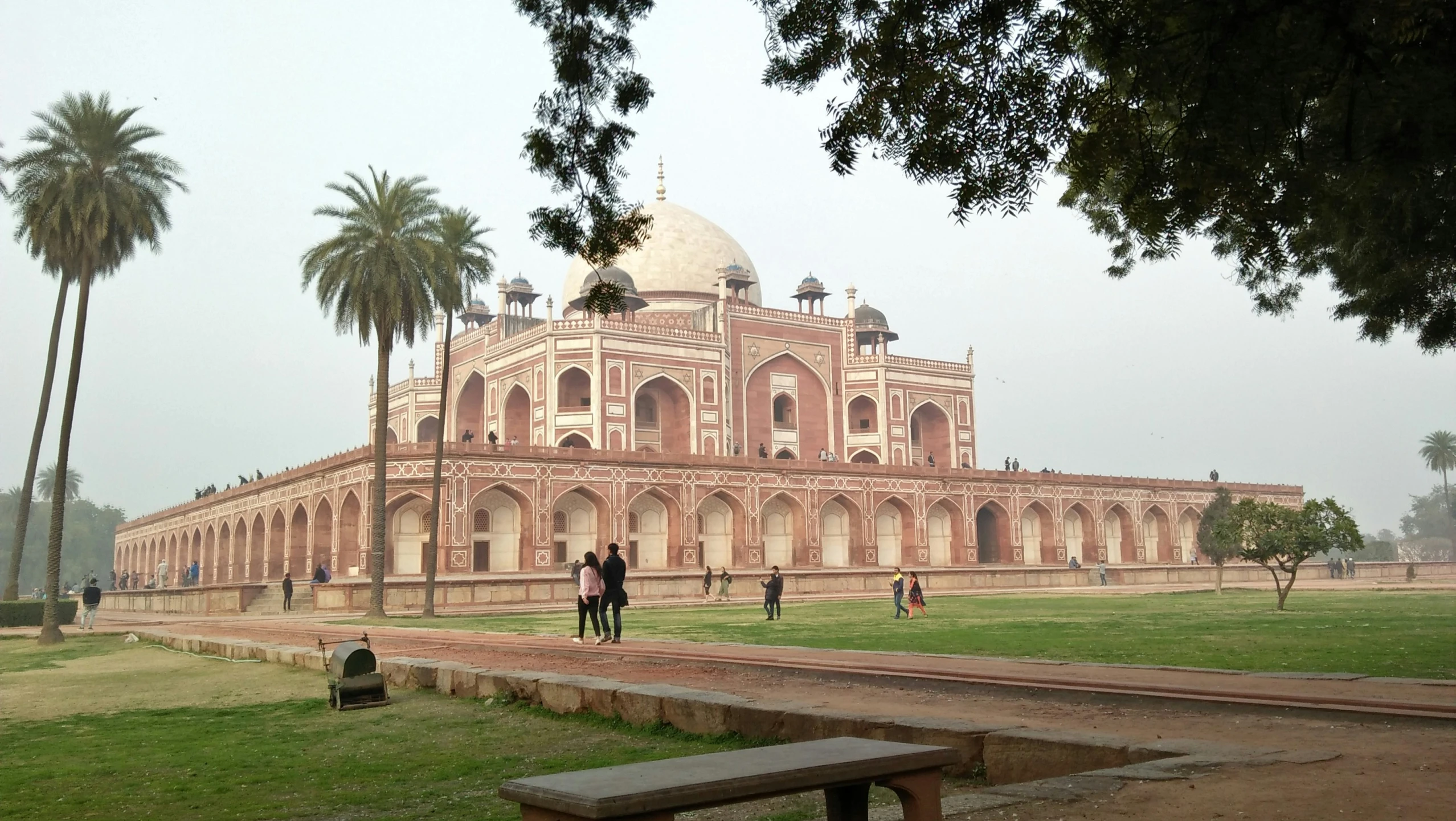 a large building sitting next to palm trees in a park