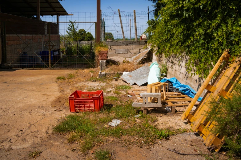 a chair and two tables in a dirt yard