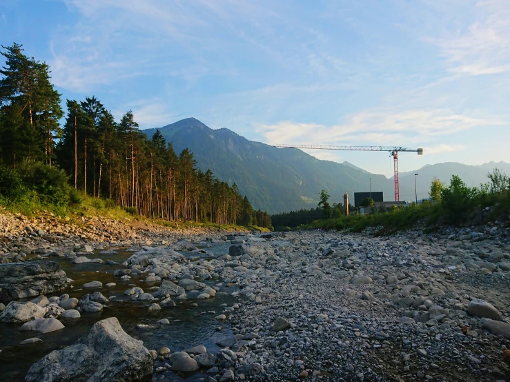 a view of a river with rocks and trees near by