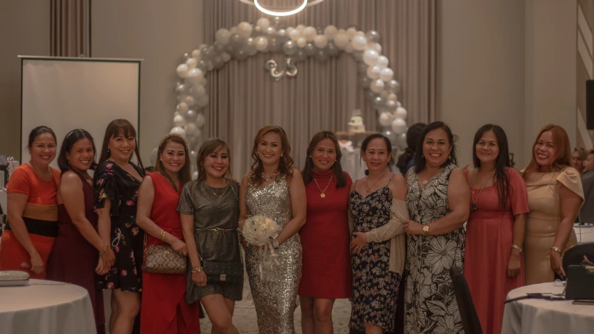 several women in dresses posing for a po