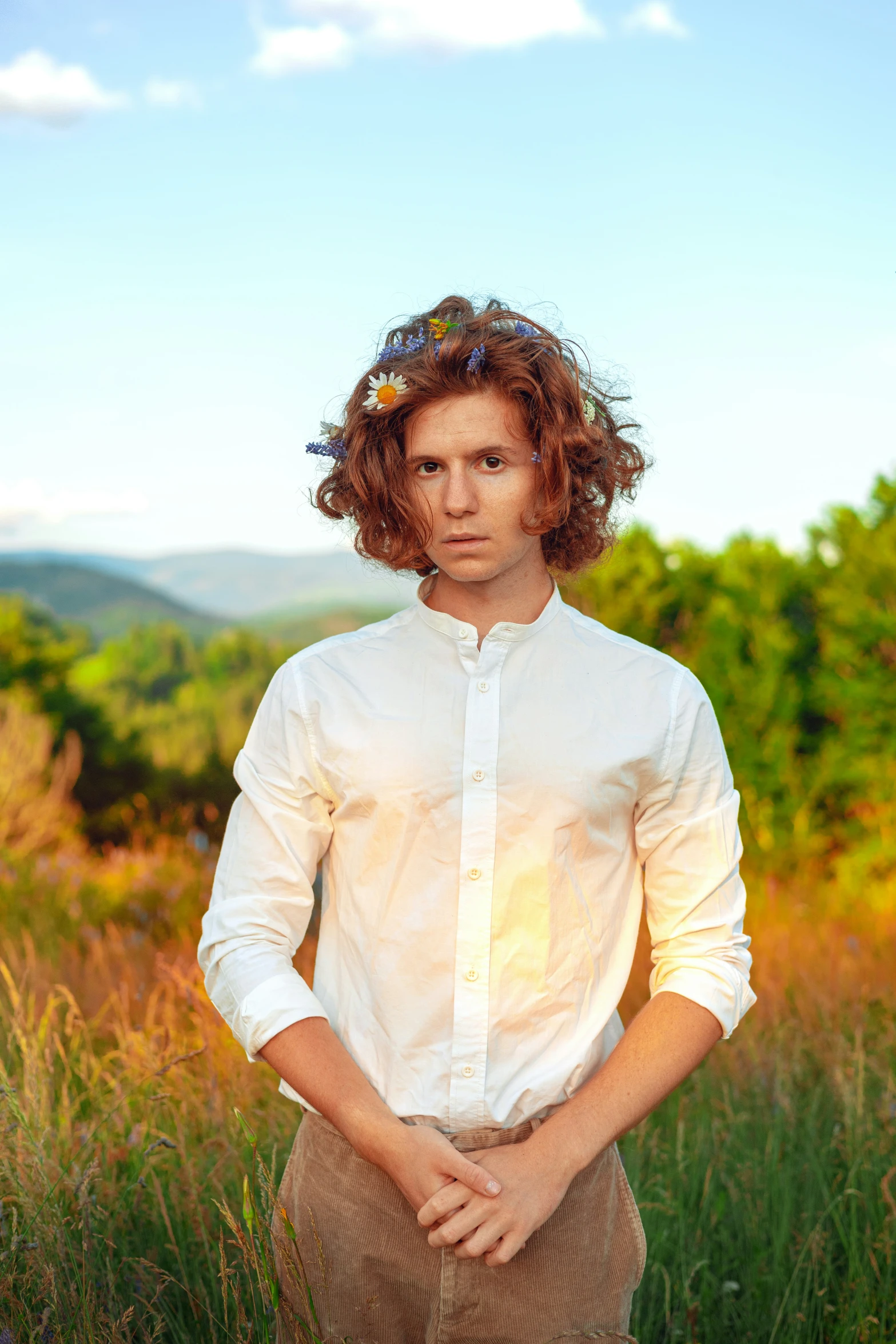 a man standing in the grass looking towards the camera