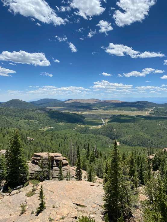 view of the mountains with lots of green trees on top