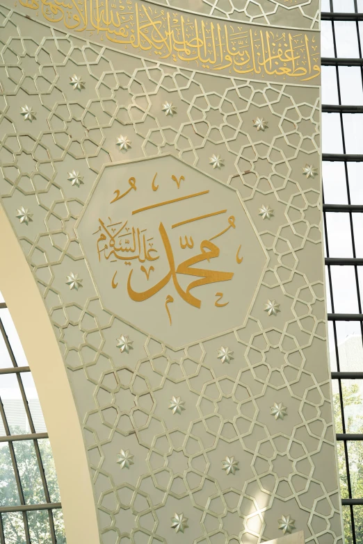 the wall in front of the window has an arabic calligraphy