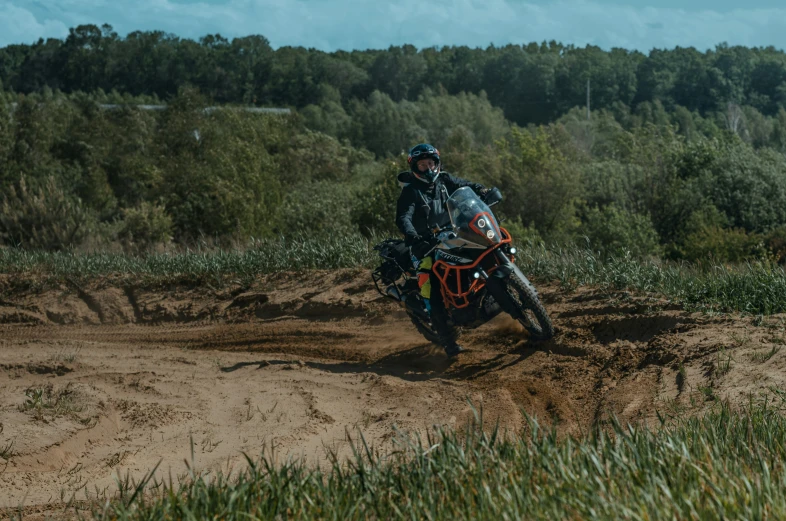 a person on a motorcycle riding down a dirt track