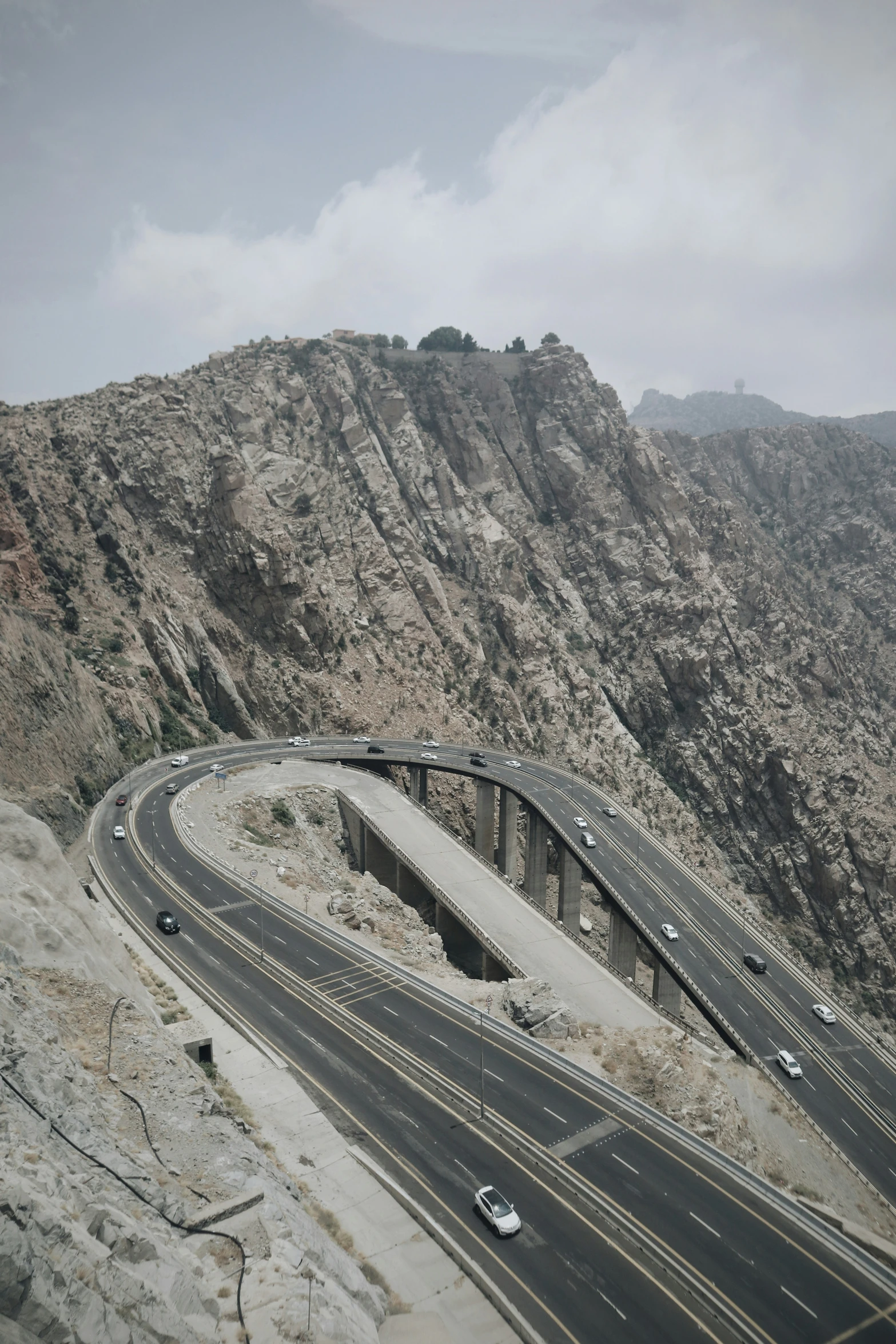 a highway passes below a mountainous mountain and bridge