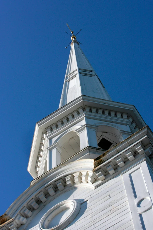 a white building with a weather vane on top