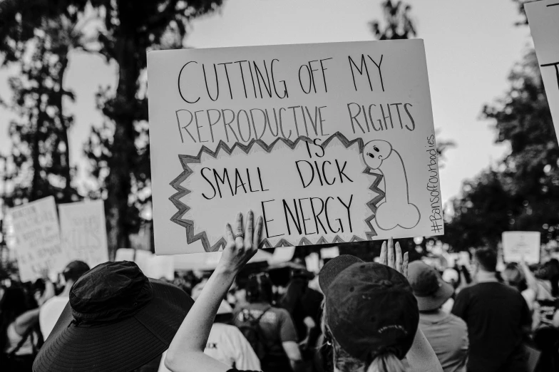 people hold signs as they march through the street