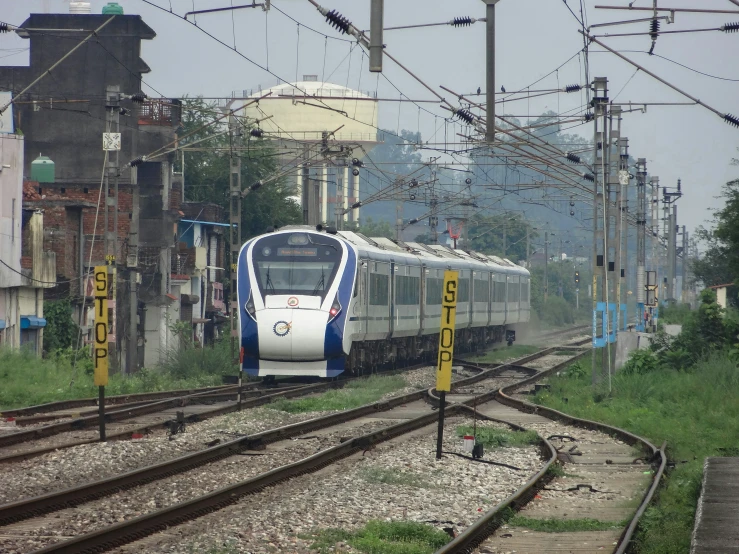 an electric commuter train on the tracks near buildings