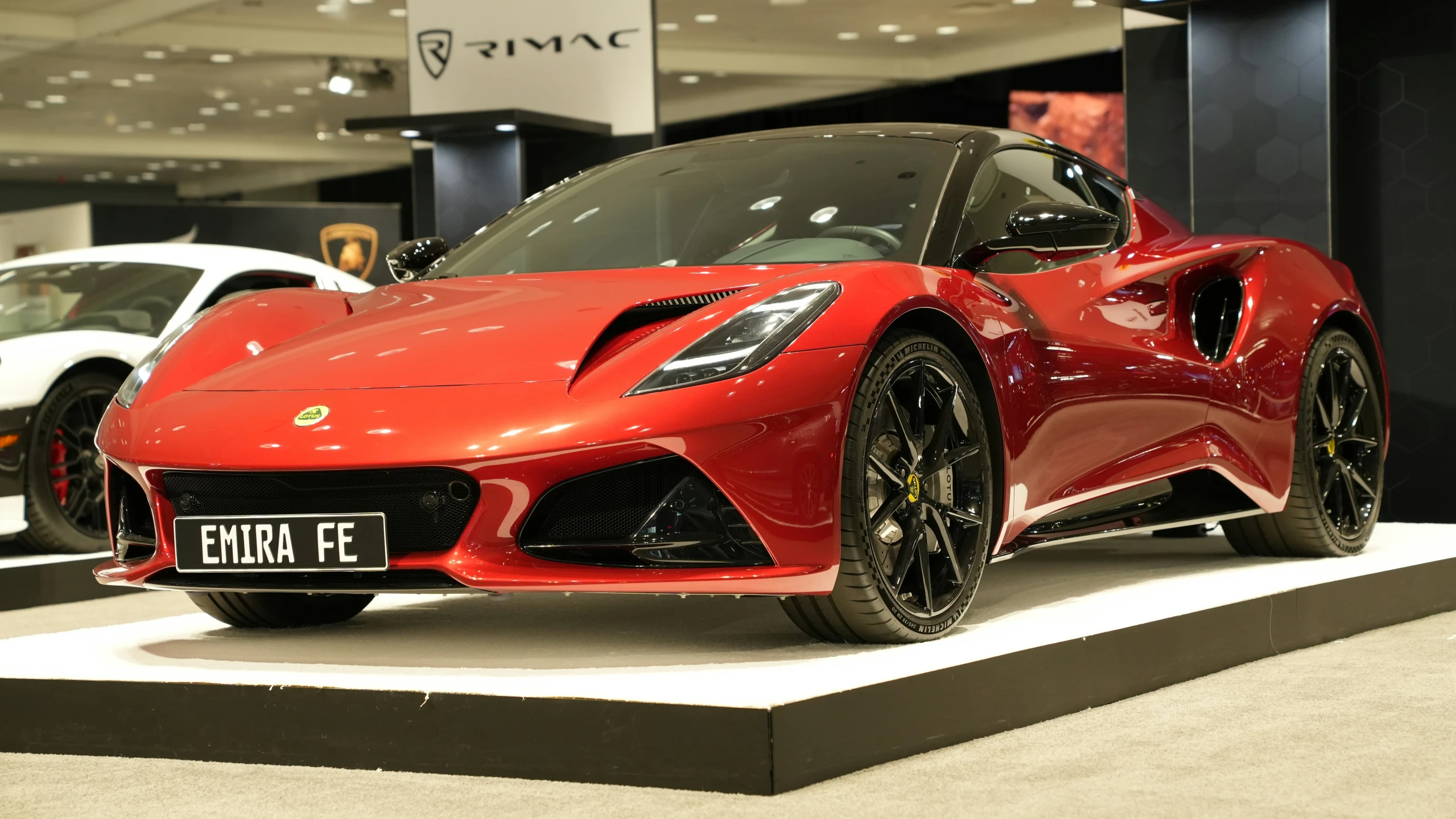 two cars are parked on display in a show room