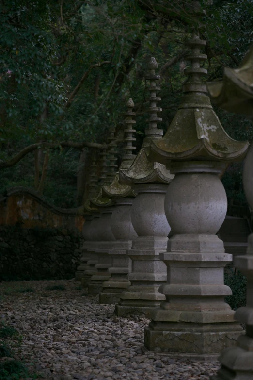 a large row of stone lanterns in front of some trees