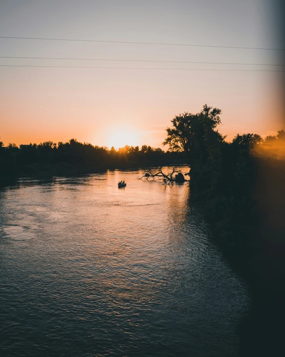 a beautiful sunset behind two canoes on the water