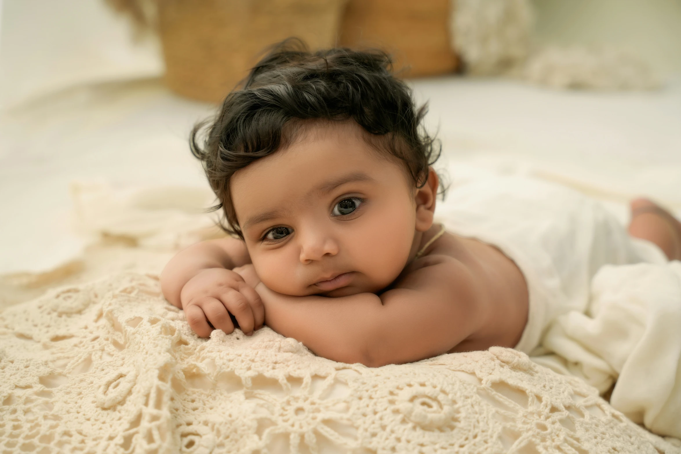 an adorable young infant laying on top of a bed