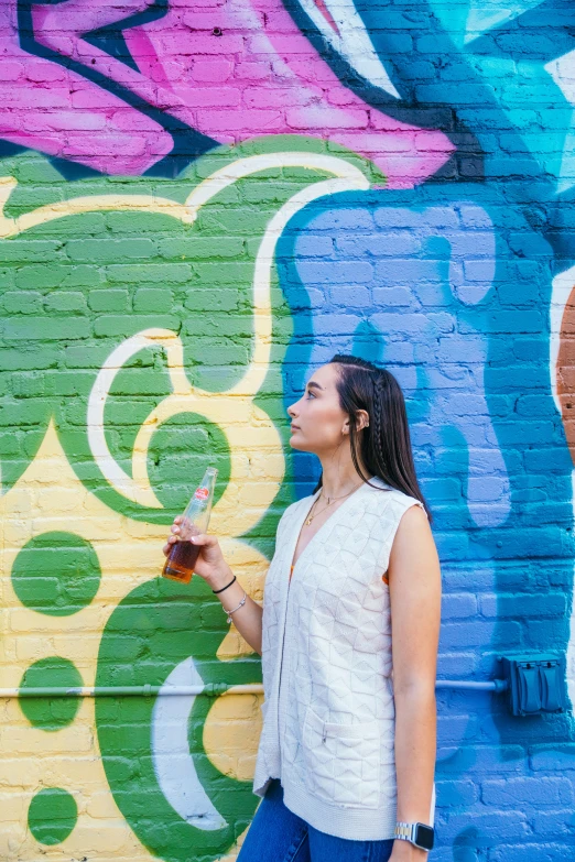 a woman with a wine glass against a colorful wall