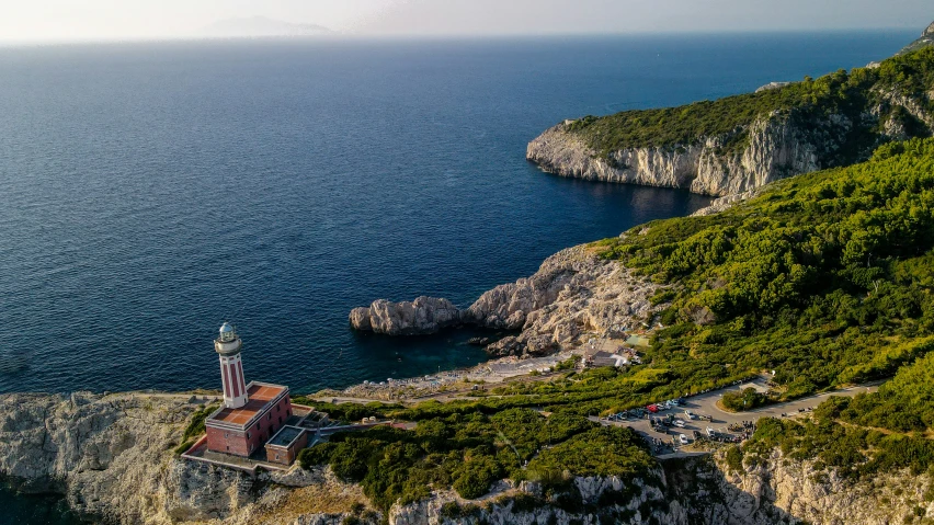 a light house is sitting on the side of a cliff near the ocean