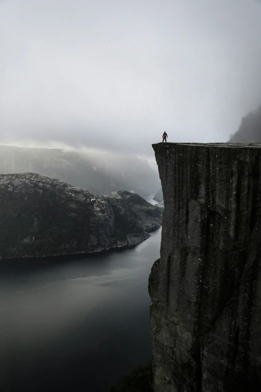 a person standing on a cliff overlooking a body of water